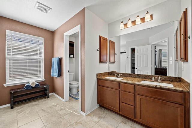 bathroom featuring toilet, vanity, and tile patterned flooring