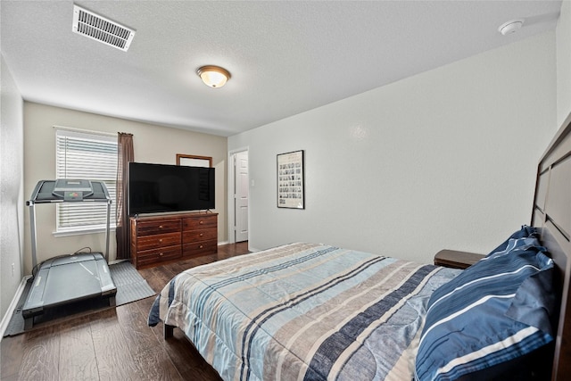 bedroom featuring dark hardwood / wood-style flooring and a textured ceiling