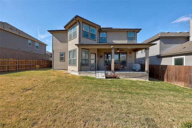 rear view of property with ceiling fan, a yard, and a patio area