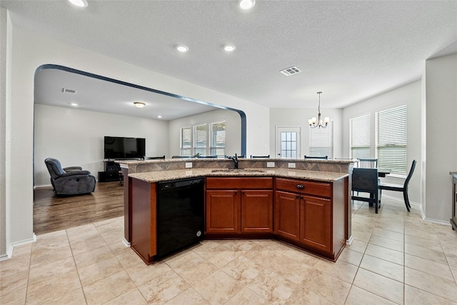 kitchen with decorative light fixtures, a textured ceiling, sink, an island with sink, and dishwasher