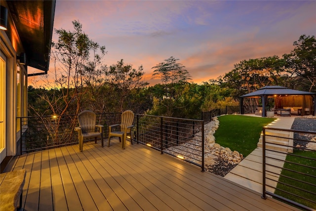 deck at dusk with a gazebo and a yard