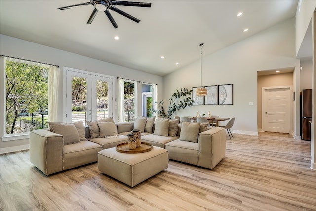 living room featuring ceiling fan, french doors, a healthy amount of sunlight, and light hardwood / wood-style floors