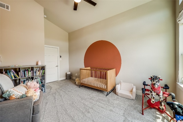 carpeted bedroom with lofted ceiling, ceiling fan, and a crib