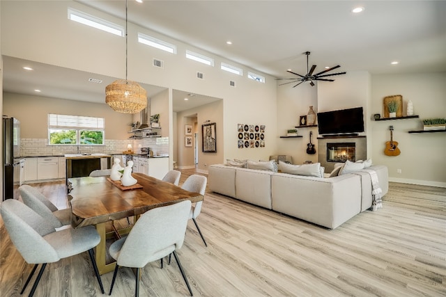 dining area featuring light hardwood / wood-style flooring, ceiling fan, and sink