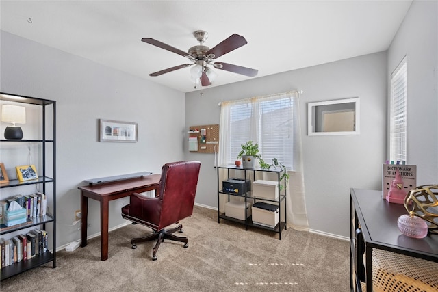 carpeted home office featuring baseboards and ceiling fan