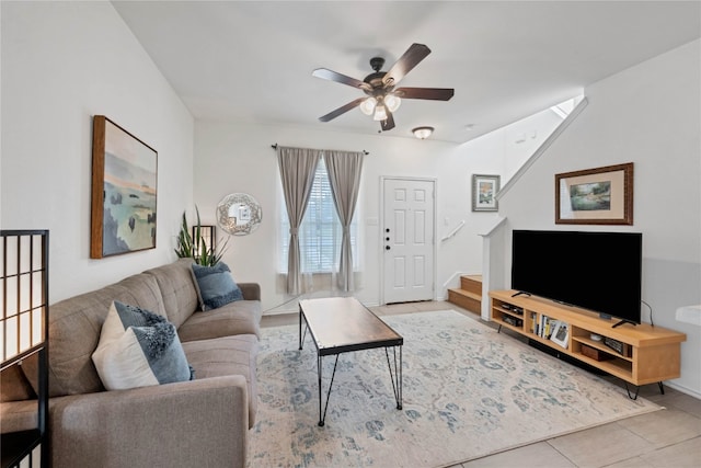 living room with stairs, tile patterned flooring, and ceiling fan