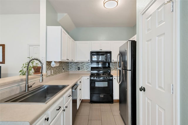 kitchen with light countertops, decorative backsplash, white cabinets, black appliances, and a sink