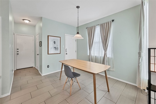 unfurnished dining area with baseboards and wood finish floors