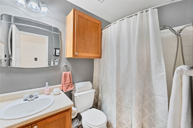 bathroom with vanity, curtained shower, and toilet