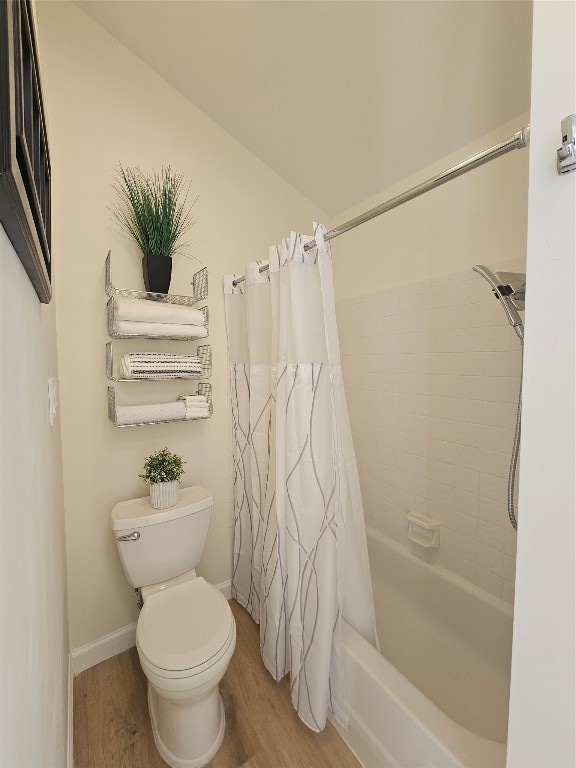 bathroom with shower / bath combo, toilet, and wood-type flooring