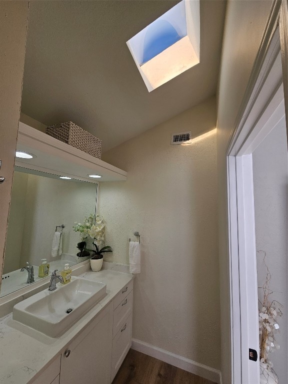 bathroom with vanity, wood-type flooring, and a skylight