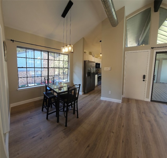 dining area featuring a chandelier, dark hardwood / wood-style flooring, and high vaulted ceiling