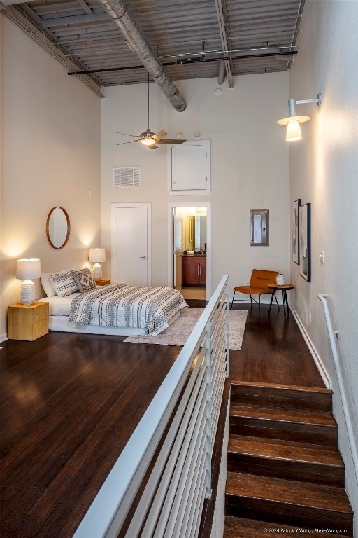 bedroom featuring dark wood-type flooring, a high ceiling, track lighting, and ceiling fan