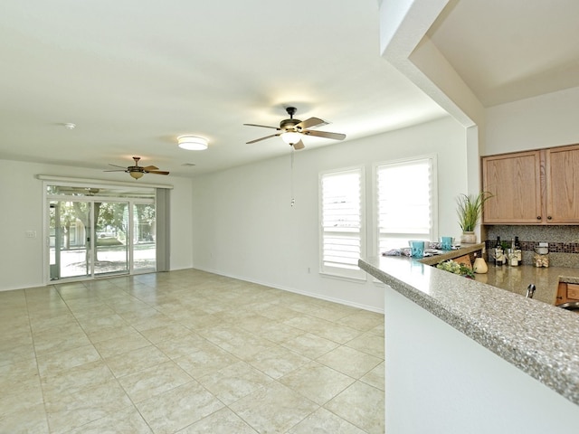 kitchen with ceiling fan, light tile patterned floors, and tasteful backsplash