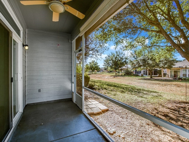 unfurnished sunroom featuring ceiling fan