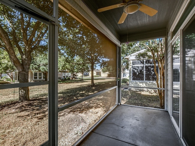 unfurnished sunroom with ceiling fan