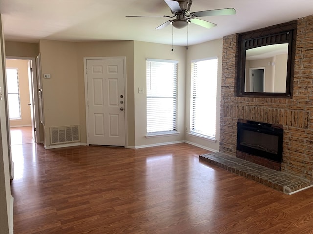 unfurnished living room with a fireplace, wood-type flooring, and ceiling fan