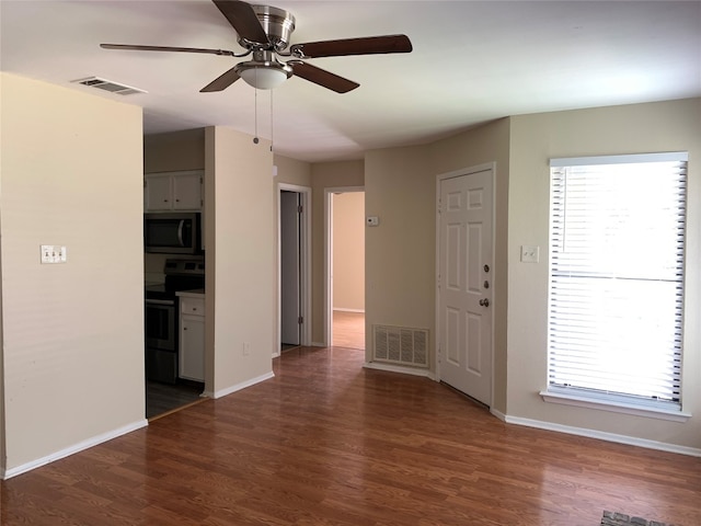 interior space with dark wood-type flooring and ceiling fan