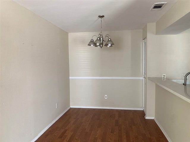 unfurnished dining area featuring dark hardwood / wood-style floors and a notable chandelier