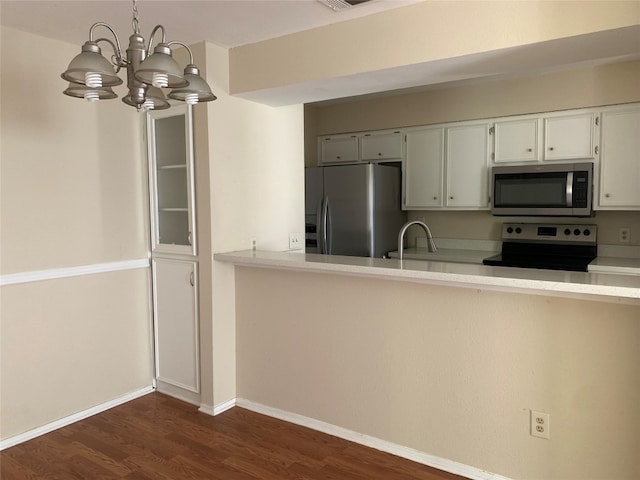 kitchen featuring stainless steel appliances, dark hardwood / wood-style floors, hanging light fixtures, a notable chandelier, and white cabinets