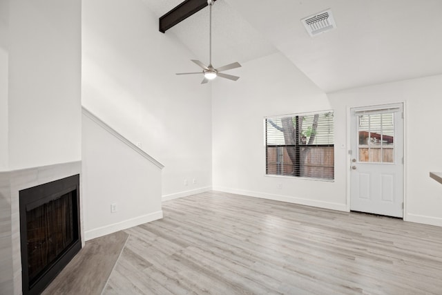 unfurnished living room with high vaulted ceiling, light hardwood / wood-style floors, ceiling fan, and beam ceiling