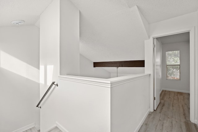 laundry area featuring a textured ceiling and light wood-type flooring