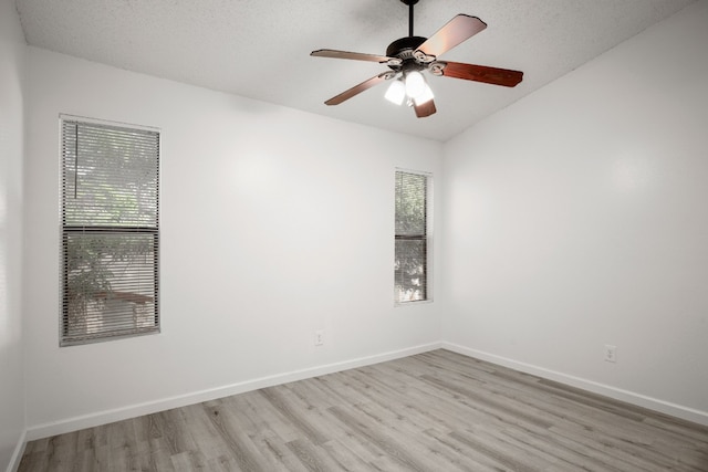 unfurnished room featuring a textured ceiling, light hardwood / wood-style floors, lofted ceiling, and ceiling fan