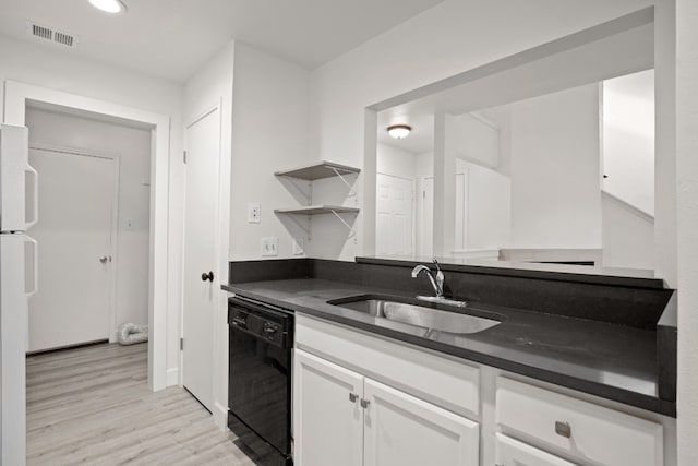 kitchen featuring light hardwood / wood-style flooring, sink, black dishwasher, and white cabinets