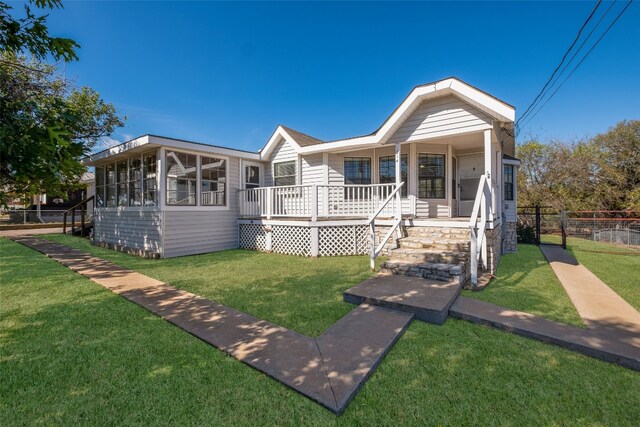 view of front of house featuring a front yard and a sunroom