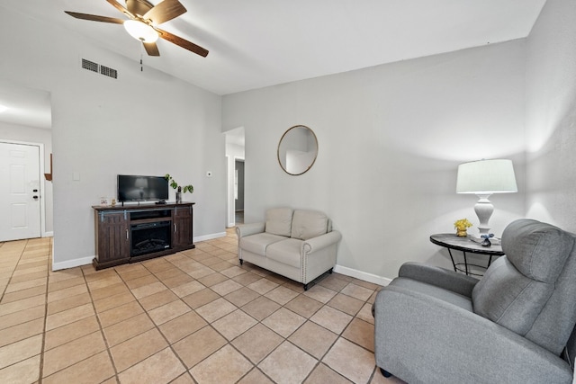 living room featuring lofted ceiling, light tile patterned floors, and ceiling fan