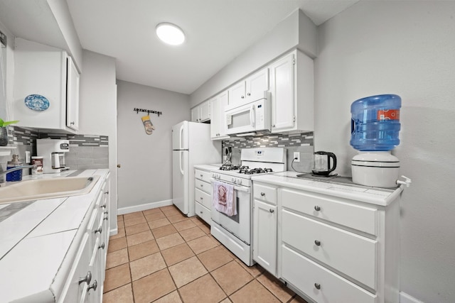 kitchen featuring decorative backsplash, white appliances, sink, and white cabinets