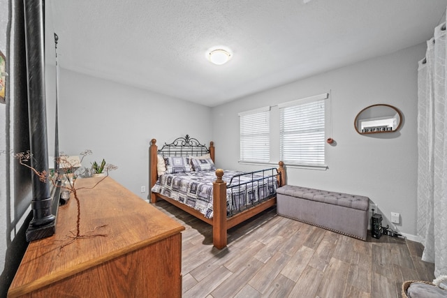 bedroom with hardwood / wood-style floors and a textured ceiling