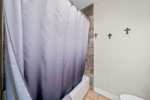 bathroom featuring tile patterned floors, toilet, and shower / tub combo