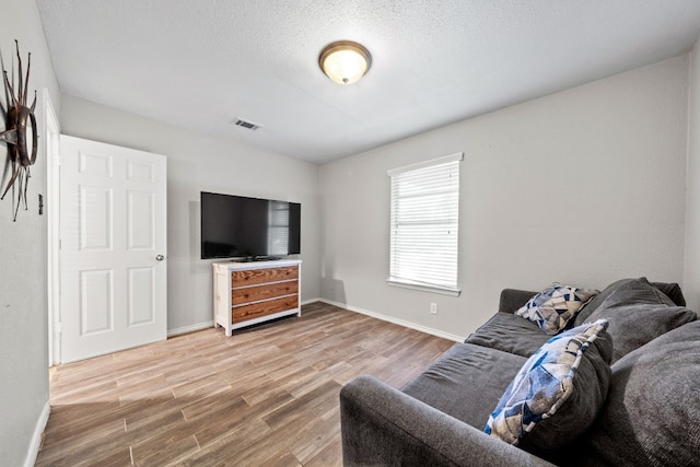 living room with wood-type flooring and a textured ceiling