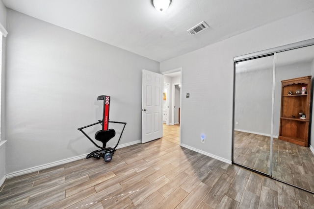 unfurnished bedroom with light hardwood / wood-style floors and a closet