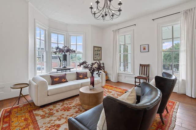 living room with light hardwood / wood-style floors, an inviting chandelier, and crown molding