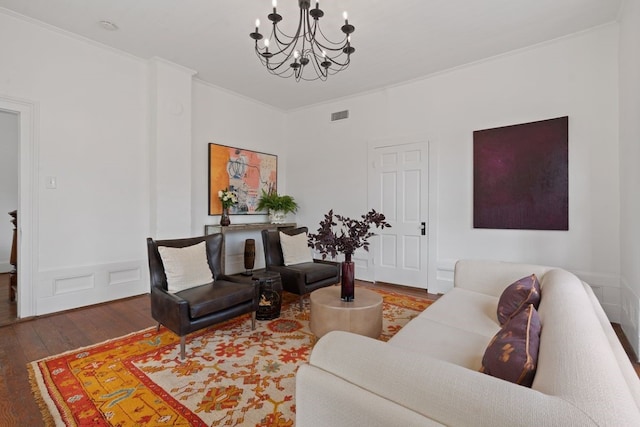 living room featuring a chandelier, wood-type flooring, and ornamental molding