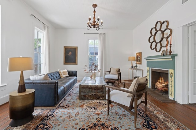 living room with ornamental molding, hardwood / wood-style flooring, and an inviting chandelier