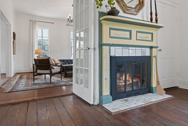 entryway with dark hardwood / wood-style flooring, an inviting chandelier, and a fireplace