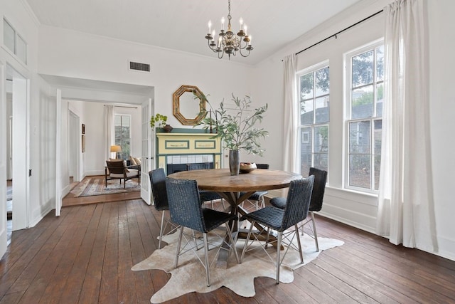 dining space with a chandelier, dark hardwood / wood-style flooring, and ornamental molding