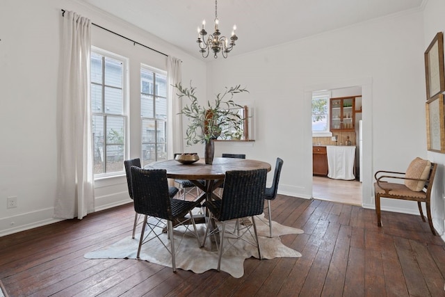 dining space featuring crown molding, dark hardwood / wood-style flooring, and a notable chandelier