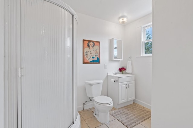 bathroom with toilet, vanity, tile patterned flooring, and a shower with shower door