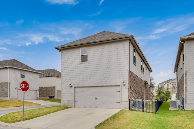 view of front facade featuring a garage, a front lawn, and central AC