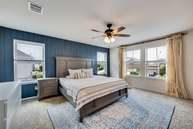 carpeted bedroom with ceiling fan and multiple windows