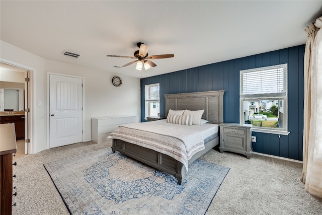 carpeted bedroom featuring multiple windows and ceiling fan