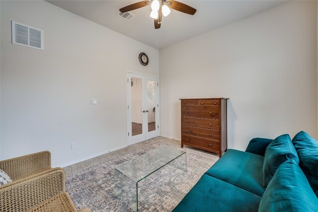 carpeted living room with french doors and ceiling fan