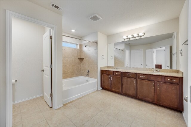 bathroom featuring vanity, tile patterned floors, and tiled shower / bath combo