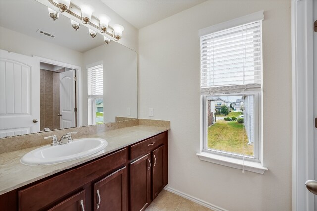 bathroom with vanity, tile patterned flooring, and a healthy amount of sunlight