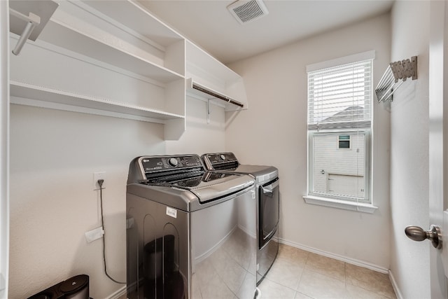 washroom with washing machine and dryer and light tile patterned floors