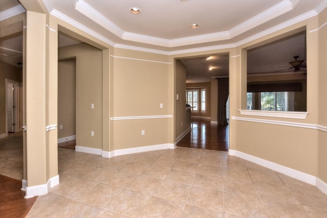 tiled spare room featuring ornamental molding, ceiling fan, and a tray ceiling